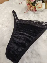 Tanga de terciopelo y encaje negro, con tiras regulables y diseño sensual.