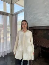 Camisa celeste con estampado de flores blancas, de corte holgado y manga larga.