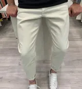 Pantalón skinny de gabardina color beige, de corte ajustado en las piernas.