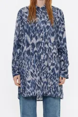 Camisa larga de viscosa con estampado de cebra en tonos azules y grises. Modelo de corte recto, cuello camisero, manga larga, puño con botones y cierre frontal de botonadura.