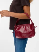Bolso de hombro color borgoña (Syrah) con efecto cuero y acabado arrugado. Presenta un cierre fruncido en la parte superior y una correa ajustable para llevar al hombro.