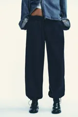 Pantalón de felpa de tiro alto con cintura elástica y corte recto. Cuenta con bolsillos laterales ocultos en la costura y bajo ajustable con cordón elástico y stoppers.