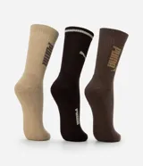 Kit de tres pares de medias deportivas Puma de caña larga, confeccionadas en algodón. Incluye un par blanco con rayas y logo azules, un par negro con rayas y logo blancos, y un par liso de color azul.
