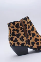 Texana de caña corta con diseño de animal print en color fucsia y negro. Presenta un taco bajo y aberturas laterales.