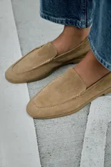 Mocasín plano de mujer confeccionado en serraje, con diseño de punta redonda, copete subido y suela con efecto engomado.