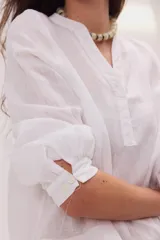Blusa de lino color marrón con cuello mao, escote en V y mangas largas.
