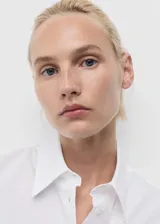 Camisa de corte recto confeccionada en una mezcla de algodón y lyocell. Presenta cuello camisero clásico, cierre frontal con botones y mangas largas con puños abotonados.