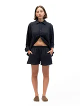 Short de lino color negro, con cintura elástica y bolsillos laterales, de diseño holgado y cómodo.