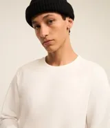 Remera de manga larga con cuello redondo, confeccionada en algodón. Presenta un corte comfort holgado y una pequeña etiqueta decorativa en el bajo.