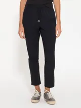 Babucha negra confeccionada en bisou, con cintura elastizada y jareta con lazo de cinta valenciana a tono. Cuenta con bolsillos laterales en el delantero y un calce cómodo.