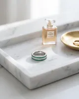 Anillo de plata con diseño de tres hileras, con circones blancos en el centro y piedras verdes en los laterales.