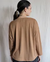 Remera de manga larga confeccionada en lanilla gris melange, con diseño holgado y escote redondo fruncido.