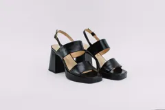 Sandalias de plataforma color crema, con tiras anchas de charol y hebilla ajustable en el tobillo.