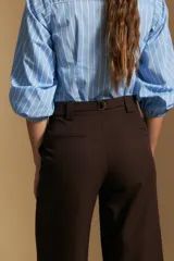 Pantalón de vestir negro de corte ancho y tiro alto, con silueta fluida y diseño minimalista.