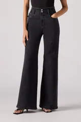 Pantalón de jean acampanado negro de tiro alto con dos botones a la vista.