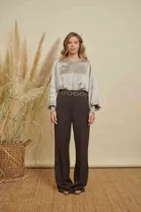 Blusa de satén color champagne con cuello a la base, mangas anchas y puños elásticos con detalle bordado.