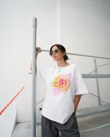 Remera blanca de algodón peinado con estampa centrada en el frente con texto en color amarillo y rosa.