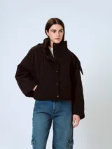 Campera puffer negra con diseño matelaseado de rombos, cuello alto y cierre con botones a presión.