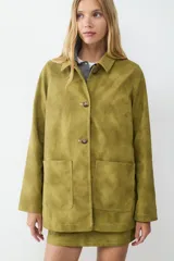 Chaqueta de manga larga color verde oliva con efecto gamuza, corte recto, cuello clásico, cierre frontal de botones y dos grandes bolsillos de parche delanteros.