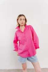 Camisa fucsia de algodón, corte clásico, manga larga y cierre con botones.