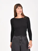 Remera de manga larga con diseño de rayas horizontales en blanco y negro, cuello redondo y ajuste al cuerpo.