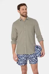 Short de baño celeste con estampado floral blanco, cintura con elástico y cordón regulable, bolsillos laterales y suspensor de malla fina.