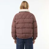 Campera acolchada corta color marrón con cuello de borreguito color crema. Presenta cierre frontal con botones a presión y bolsillos con solapa en el pecho.