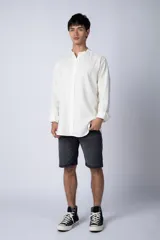 Camisa de lino color blanco con cuello mao y cierre frontal de botones. Presenta mangas largas con puños simples y un corte clásico.