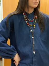 Collar largo confeccionado con cuentas multicolor de diversos materiales, formas y tamaños, incluyendo cristales checos, piedras naturales, acrílico y cerámica. Cuenta con cierre de cadena de acero quirúrgico y ganchito regulable.