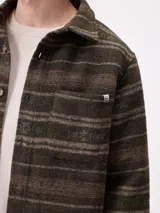 Camisa de manga larga con diseño de estampado étnico en tonos azules y beige. Presenta cuello clásico, cierre frontal con botones y bolsillos en el pecho.