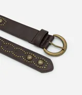 Cinturón de cuero sintético color marrón oscuro, con diseño decorativo de tachas metálicas grandes y pequeñas en tono oro envejecido. Presenta una hebilla redondeada metálica y pasador reforzado.