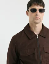 Campera Harrington de gamuza en color marrón, con cierre frontal, cuello clásico y bolsillos laterales con solapa.