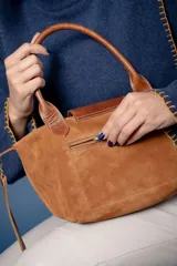 Cartera pequeña de mano tipo tote, confeccionada en gamuza color azul, con solapa y asas en cuero sintético con textura de reptil. Incluye cierre superior y correa larga ajustable y extraíble.