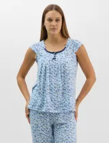 Pijama compuesto por remera sin mangas con escote redondo, botones frontales y detalle de puntilla, acompañado de un pantalón capri con cintura elástica. Presenta un estampado floral en tonos rosados sobre base gris.