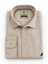 Camisa de lino color blanco, manga larga, con cuello corto clásico y bordado de un ave oscura en el pecho.