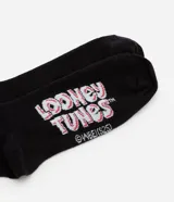 Par de medias de caña media color negro con estampa de Daffy Duck y logo de Looney Tunes.