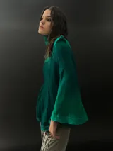 Buzo verde esmeralda de lana merino con cuello alto y mangas largas. Presenta dos texturas: afieltrada en cuello, mangas y ruedo, y tejido merino superfino en el delantero y la espalda.