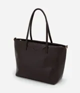 Cartera tipo shopper de gran tamaño, confeccionada en poliuretano con textura efecto crocco. Presenta doble asa fija para llevar al hombro y una correa larga desmontable con herrajes dorados. Cuenta con cierre superior por cremallera.