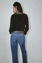 Jersey negro de manga larga con escote en V adornado con encaje negro.