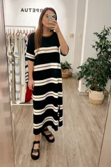 Vestido largo de tejido de punto a rayas horizontales negras, blancas y marrones.