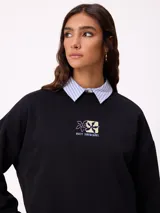 Sweater negro de corte holgado con estampado trasero de flores y el logo "Rusty" en colores neón.