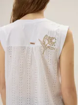 Remera sin mangas de algodón con elastano, color negro con detalles en tono tostado en los hombros, corte recto y diseño básico.