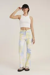 Pantalón de jean de tiro alto con estampado tie-dye en tonos celeste, amarillo y blanco.