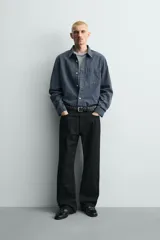 Pantalón jeans de corte recto y ajuste holgado, confeccionado en denim de algodón rígido. Presenta diseño clásico de cinco bolsillos, cierre frontal con cremallera y botón, con un acabado de lavado claro.