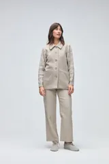 Trench de lana fina sin teñir, con diseño de textura combinada. Presenta mangas y espalda tejidas con patrón de trenzas, cuerpo liso, cuello camisero, cierre frontal con botones y bolsillos delanteros funcionales.