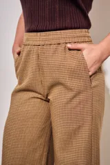 Pantalón de corte ancho con estampado a cuadros vichy en tonos marrón y tostado, cintura elástica y diseño fluido.
