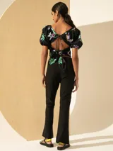 Pantalón negro de cuero en la parte delantera y lycra en la parte trasera, con corte ajustado y aberturas en el ruedo.