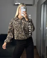 Campera bomber de gamuza con textura de corderoy, con estampado animal print de leopardo, cuello camisero, cierre frontal completo y bolsillos delanteros.