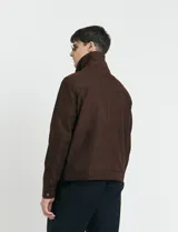 Campera Harrington de gamuza en color marrón, con cierre frontal, cuello clásico y bolsillos laterales con solapa.