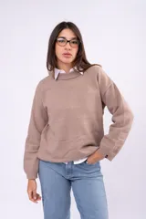 Sweater de punto liso en color beige, con cuello redondo, mangas largas y calce relajado.